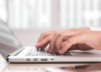 Closeup of business woman hand typing on laptop keyboard