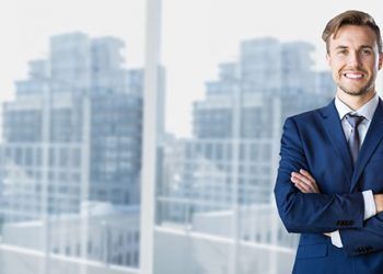 Businessman standing with arms crossed in office