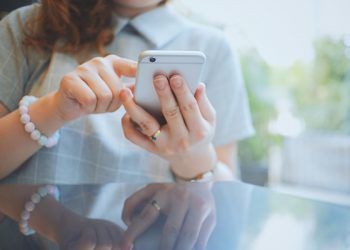 Woman using smartphone or mobile phone in the cafe