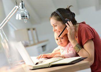 Busy businesswoman working with baby on lap
