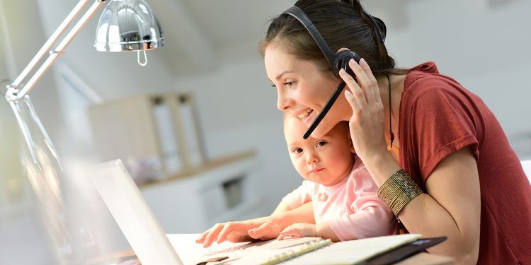Busy businesswoman working with baby on lap