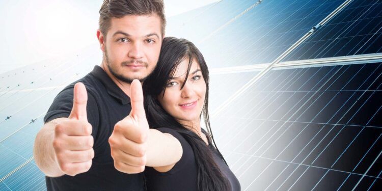 Happy couple showing like on solar power photovoltaic panel background as green energy solution concept