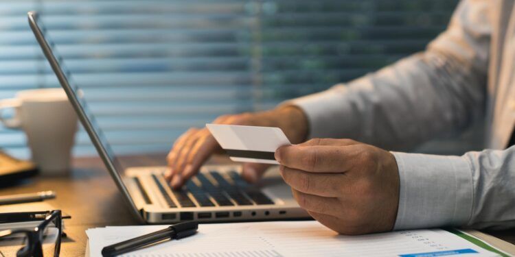 Businessman doing online banking, he is making e-payments with a credit card and his laptop, online business and finance concept