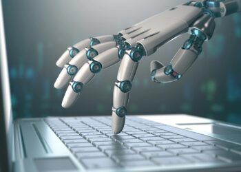 Robotic hand, accessing on laptop, the virtual world of information. Concept of artificial intelligence and replacement of humans by machines.