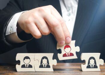 A businessman collects puzzles symbolizing a team of employees. The concept of creating a business team to perform tasks. Management and leadership skills. Toxic employee, weak link.