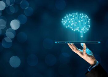 Artificial intelligence (AI), machine deep learning, data mining, and another modern computer technologies concepts. Brain representing artificial intelligence and businessman holding futuristic tablet.