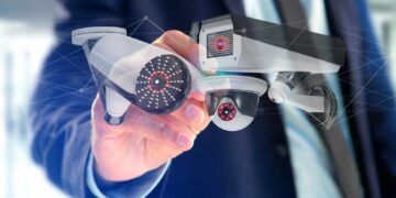 View of a Businessman holding a Security camera system and network connection - 3d rendering