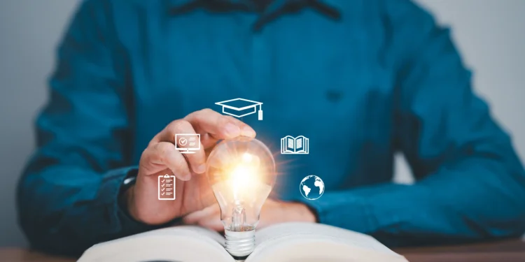 Hombre mirando un foco de luz inspirado en ideas de educación al abrir el libro